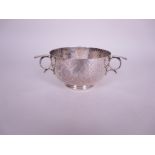 A George V silver three handled Christening Bowl with hammered design and engraved initials,