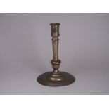 A late 17th/early 18th Century brass Candlestick with knopped and tapering stem on stepped