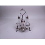 A George III silver five bottle Cruet with central spiral handle on scroll supports with shell feet,