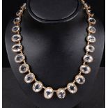 A white Spinel Riviere Necklace set twenty eight graduated oval-cut stones in silver gilt,