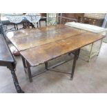 An 18th Century oak large Wake type Table with drop leaves, fitted one end drawer on square supports