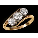 A Diamond three stone Crossover Ring millegrain-set graduated old-cut stones, stamped 18ct, ring