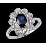 A Sapphire and Diamond Cluster Ring millegrain-set oval-cut stone within frame of ten old-cut