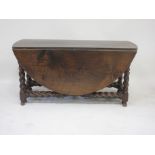 A large antique oak double gateleg Table, oval drop-leaf top above barley twist leg and