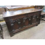 A 17th Century oak Coffer with plank lid above gouge carved frieze and three arcaded panels