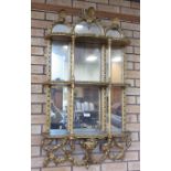 A Georgian gilt framed set of mirror back Wall Shelves of three tiers with shell surmount and floral