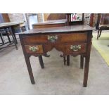 A Georgian oak Lowboy fitted one long and two short drawers around a shaped apron on chamfered