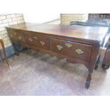 An 18th Century oak Dresser Base fitted three frieze drawers above a shaped frieze on turned