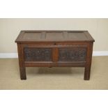 An antique oak Coffer with three sunken panel lid above pair of rosette carved front panels, 3ft