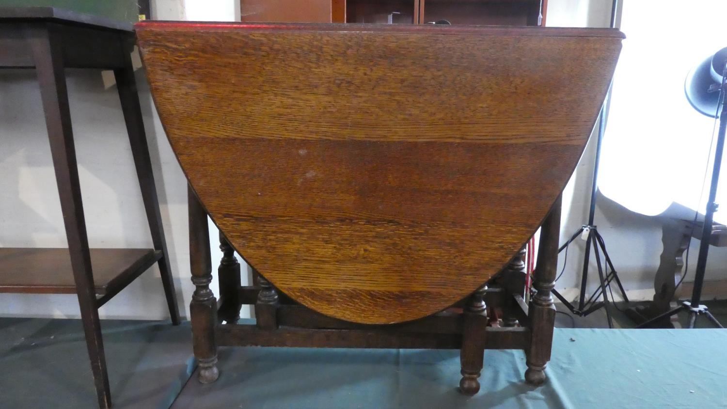An Edwardian Oak Oval Topped Drop Leaf Gate Legged Dining Table. 87cm Wide