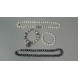 A Collection of Four Strings of Pearls, One with Silver Clasp