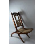 A Late Victorian Mahogany Folding Chair with Carved and Pierced Top Rail and Caned Seat and Back