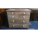 A Stripped Pine Chest of Two Short and Three Long Drawers with White Ceramic Handles, 97cm wide