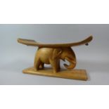 A Carved Wooden African Head Rest in the Form of an Elephant, 38cm Wide