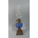A Late Victorian Cold Painted Iron Based Oil Lamp with Blue Glass Reservoir