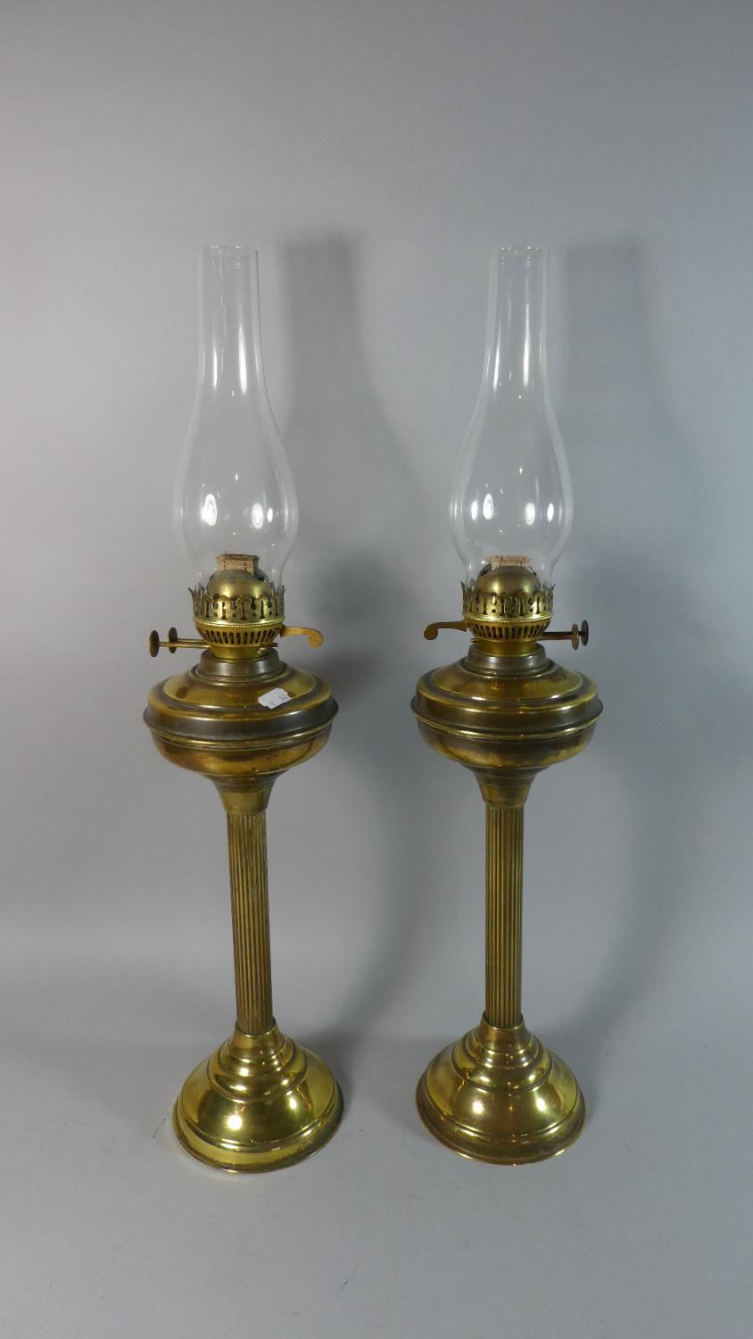 A Pair of Tall Brass Oil Lamps with Glass Chimneys, Lamps 48cm High