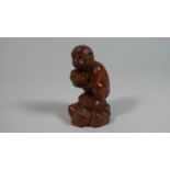 A Carved Wooden Netsuke in the form of a Monkey Set on Naturalistic Base Clutching Coconut, 6cm High