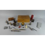 A Wooden Box Containing Curios to Include Tape Measure, Corkscrew, Fishing Reel, Novelty Pencil