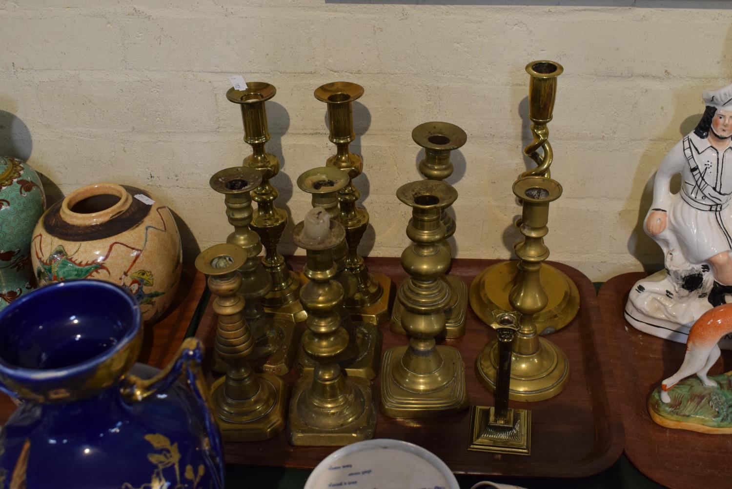 A Tray Containing Various Brass Candlesticks