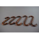 A Collection of Five Graduated Copper S Hooks