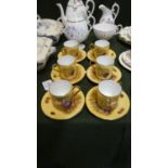 A Set of Six Aynsley Orchard Gold Coffee Cans and Saucers