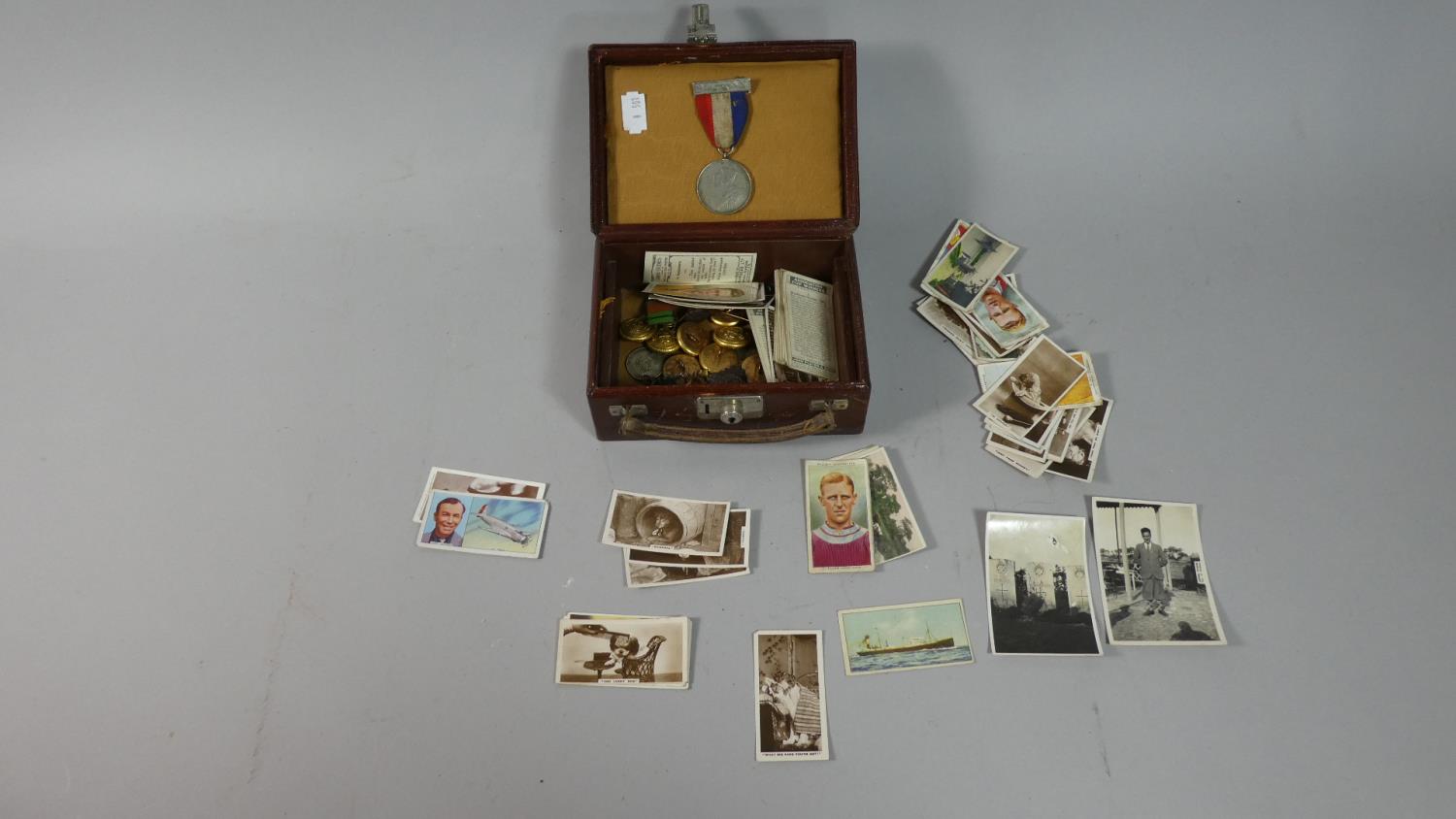 A Miniature Vintage Case Containing Military Buttons and Badges, Cigarette Cards, Coins and