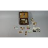 A Miniature Vintage Case Containing Military Buttons and Badges, Cigarette Cards, Coins and