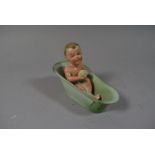 A German Porcelain Figure of a Crying Baby in Bath, Chip to Bath Rim 10cm high x 14cm wide