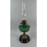 A Late Victorian Brass and Ceramic Oil Lamp with Green Glass Reservoir Decorated with Flowers