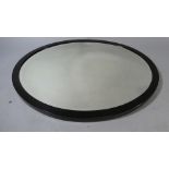 A Late 19th Century Oval Wall Mirror with an Ebonised Wooden Frame and The Original Bevelled Edge