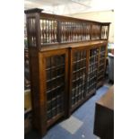 A Good Arts and Crafts Oak Break Fronted Glazed Bookcase with Extended Raised Gallery, 215 cms Wide