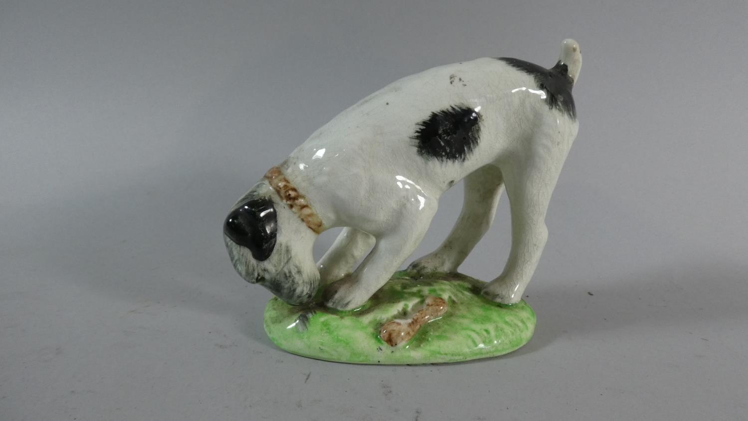 A Staffordshire Ceramic Study of Terrier Burying Bone, 11cm High (Tail Glued)