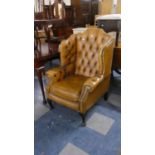 A Buttoned Leather Wing Arm Chair with Brass Stud Work, Cat Damage to Side