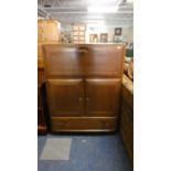 An Ercol Cabinet with Pull Down Top Section, Central Two Door Cupboard and Base Drawer, 82cm Wide