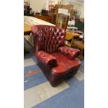 An Oxblood Leather Buttoned Upholstered Armchair, Missing Caster and Seat Cushion Ripped