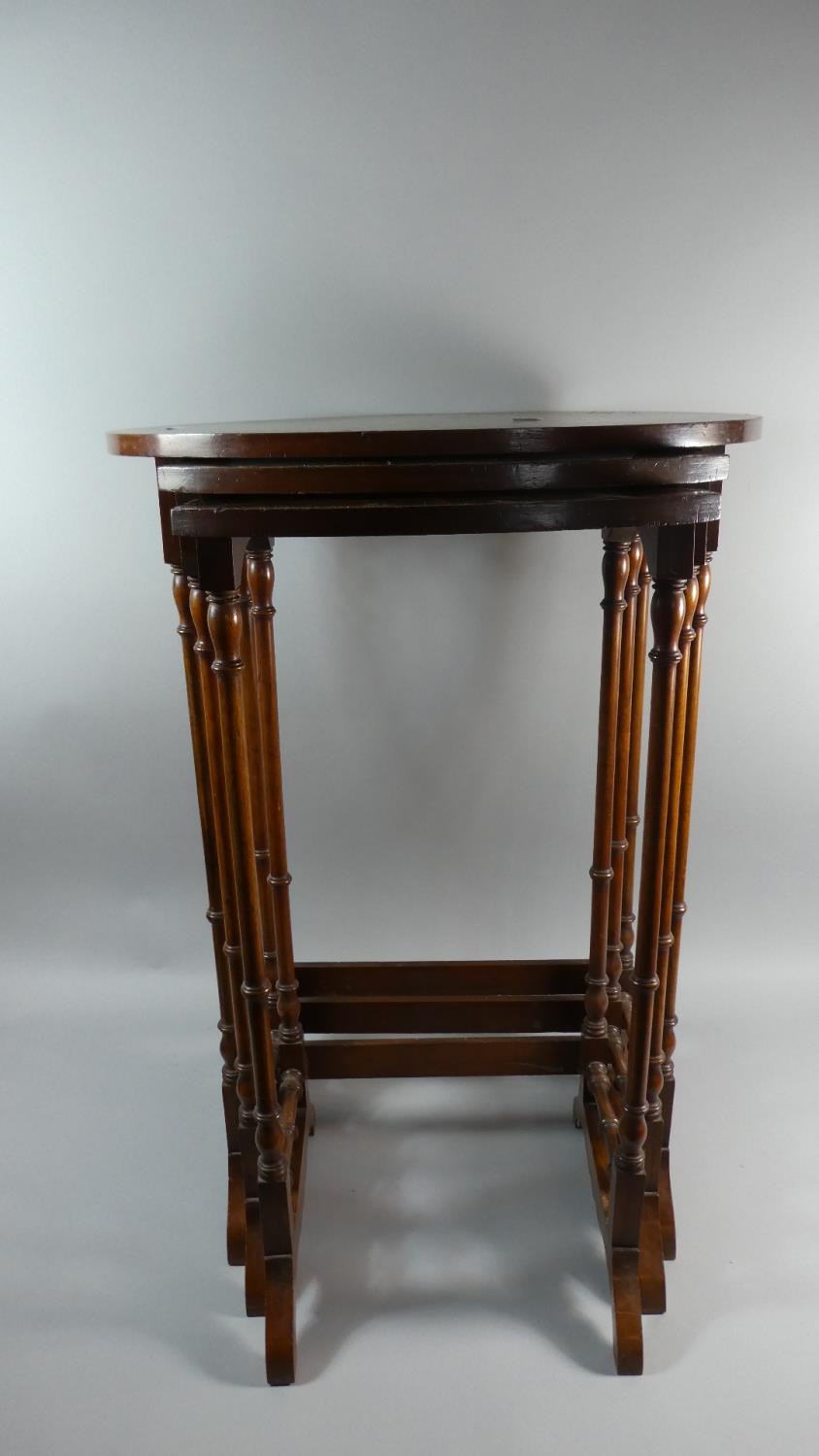 A Burr Wood Nest of Three Oval Top Tables with Spindle Supports, the Widest 50cm