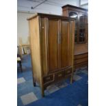 An Oriental Hardwood Cabinet with Three Base Drawers and Panelled Doors to Fitted Interior