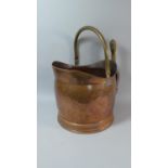 A Copper Helmet Shaped Coal Scuttle with Shovel