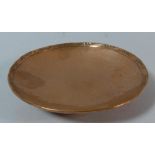 A Hammered Copper Hugh Wallis Circular Dish Set on Three Feet with Slash and Dot Design Decoration