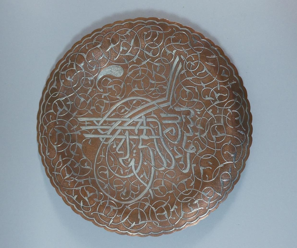 An Islamic Circular Copper Tray with Silver Overlaid Decoration on Three Feet. 30cms Diameter