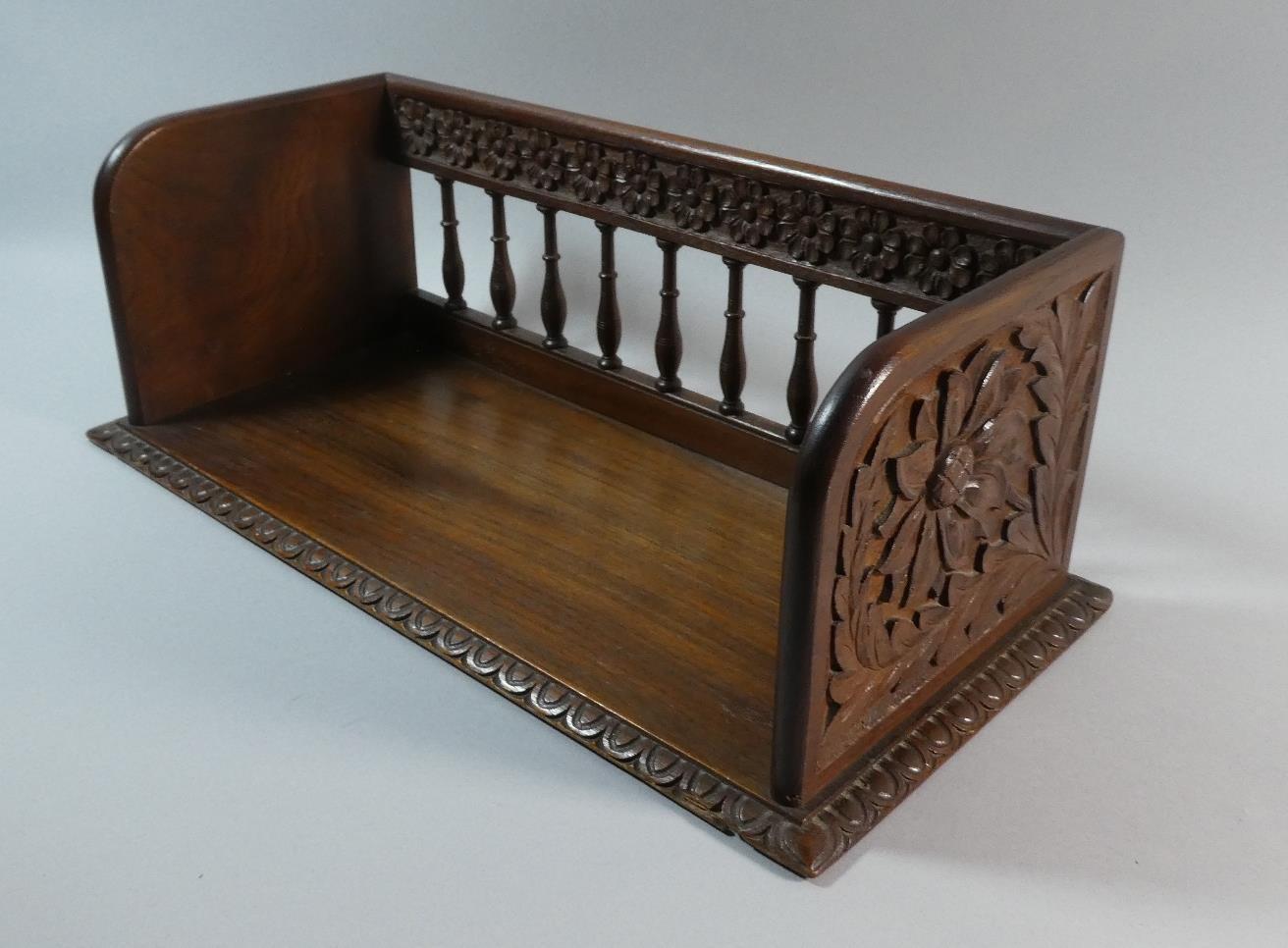 A Carved Oak Book Rest with Spindle Back and Floral Blind Carving to End Panels. 47cms Wide