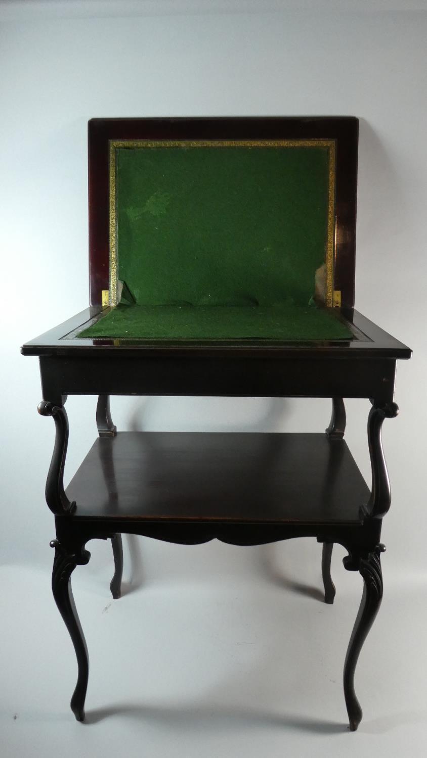 An Edwardian Two Tier Lift and Twist Games Table with Cabriole Supports. 56cms Wide