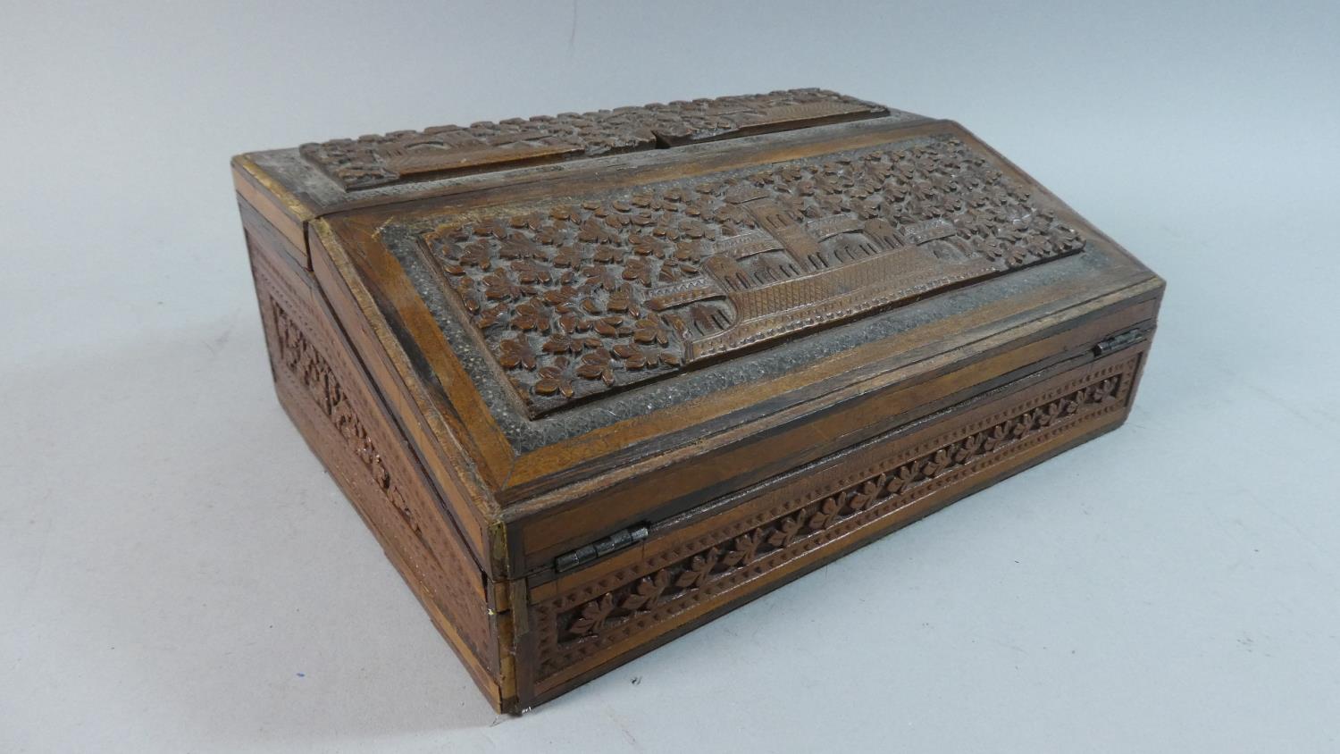 An Indian Carved Wooden Writing Slope with Stationery Box Back Having Hinged Lid and Fold Front,