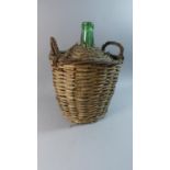 A Wicker Covered Green Glass Bottle, 38cm High