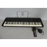 A Korg DP80 Digital Piano with Pedal, Adapter and Music Rest