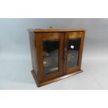 An Edwardian Glazed Smoker's Cabinet with Fitted Interior Having Two Drawers and Glass Tobacco Pot