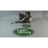 A Reproduction Cast Metal Wall Hanging Landrover Bell Together with Two Oval Land Rover Plaques (