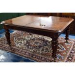 A Mid Victorian Extending Mahogany Dining Table with Turned Legs Culminating in Castors. With One