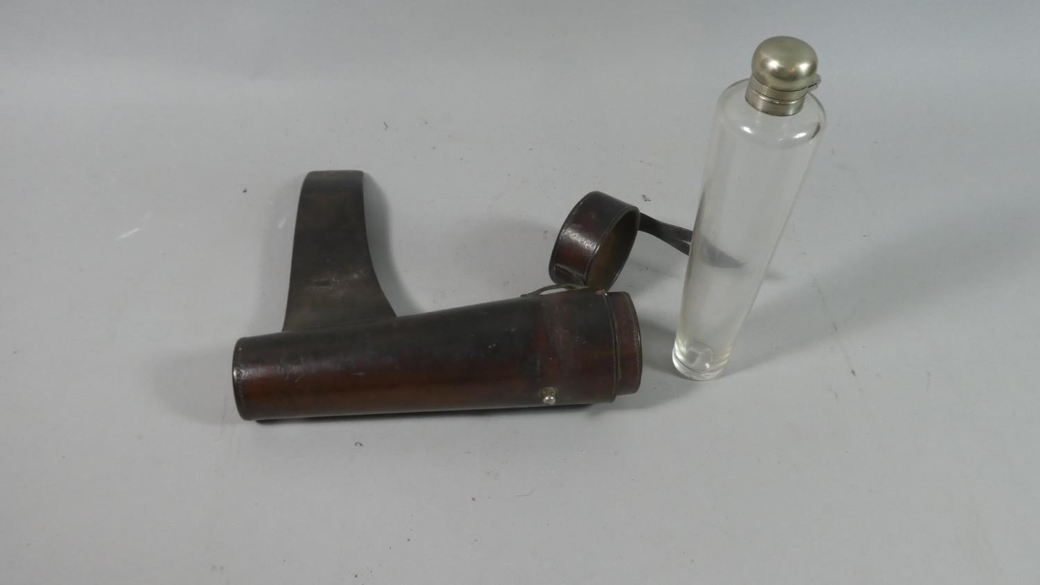 An Edwardian Tapering Glass with Silver Plate Top Hunting Flask in Leather Saddle Mounting Holder,