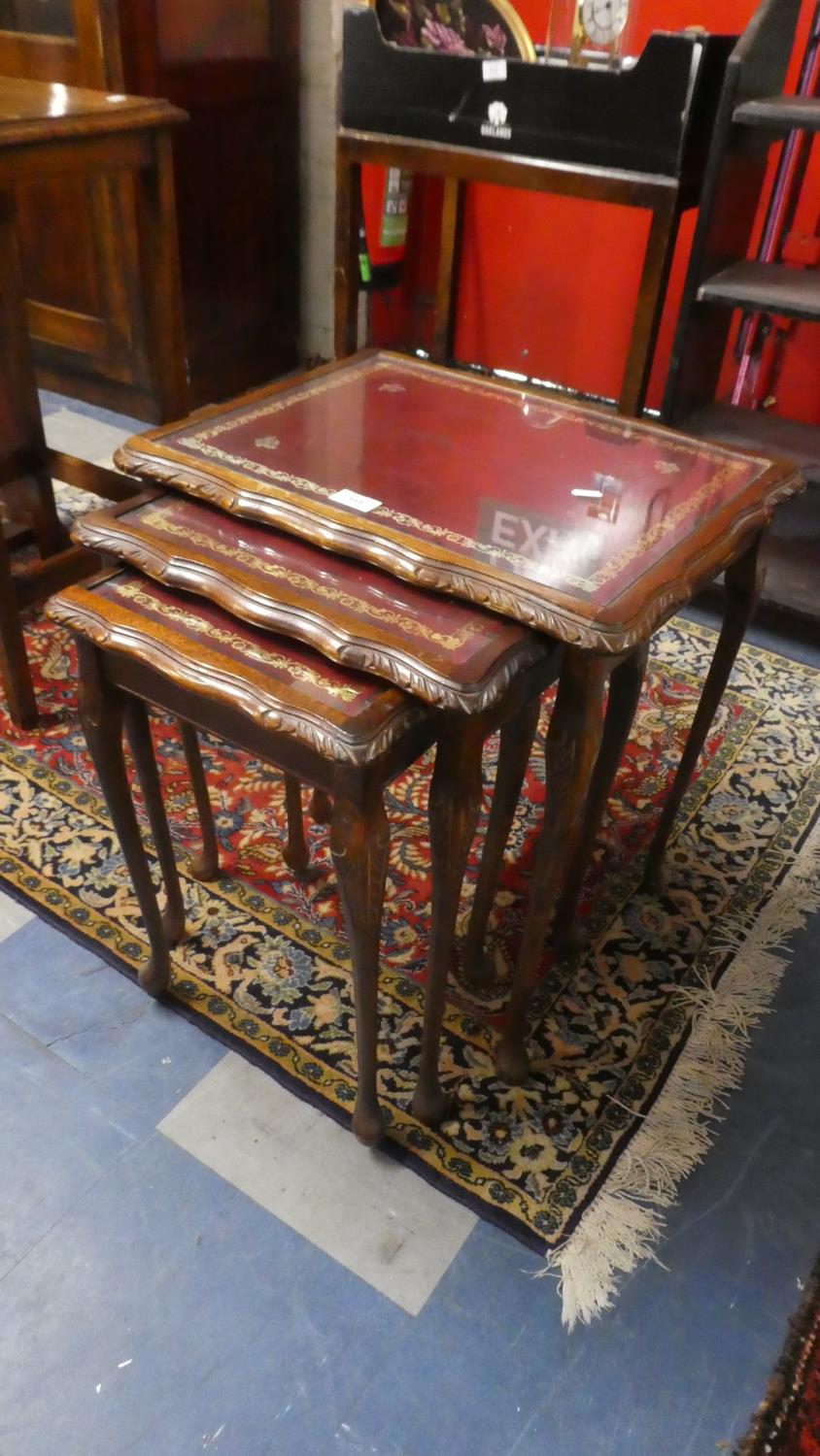 A Nest of Three Tables with Tooled Leather Tops